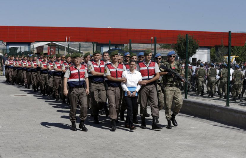 Paramilitary police and members of the special forces escort unidentified suspects of last year's failed coup outside the courthouse at the start of the trial Tuesday in Ankara, Turkey.
